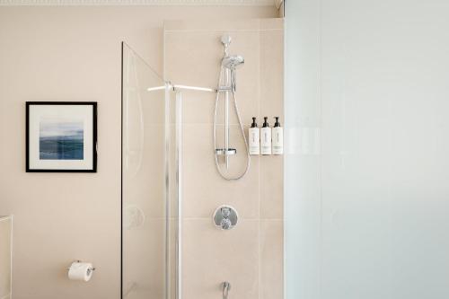 a shower with a glass door in a bathroom at voco Edinburgh - Royal Terrace by IHG in Edinburgh