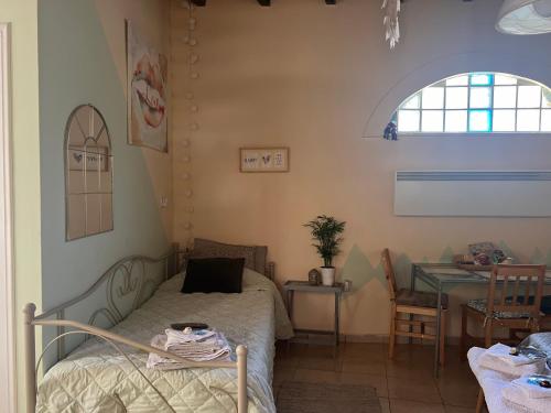 Schlafzimmer mit einem Bett, einem Tisch und einem Fenster in der Unterkunft PJ GARDEN HOUSE in Athen