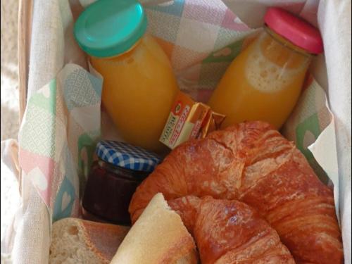 a bagel bread and two bottles of orange juice at Camping Les Ronds Duval face aux îles anglo-normandes in Les Moitiers-dʼAllonne