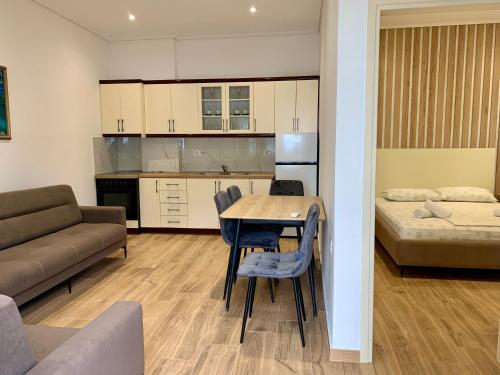 a kitchen and living room with a table and a couch at Duka Apts in Sarandë