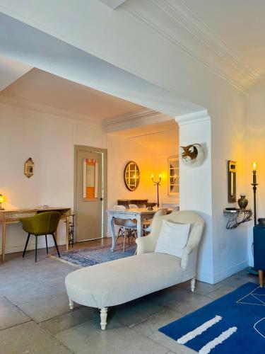un salon avec un canapé blanc et une table dans l'établissement Grand appartement au centre de l'Ecusson, à Montpellier