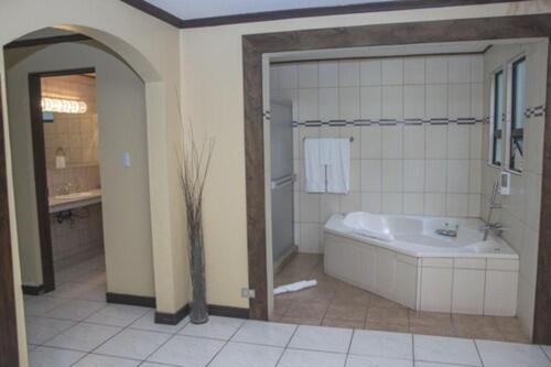 baño grande con bañera y lavamanos en Hotel El Tirol en Alto del Roble