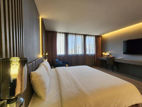 a hotel room with a bed and a television at Hualien Pink Corner Hotel in Hualien City