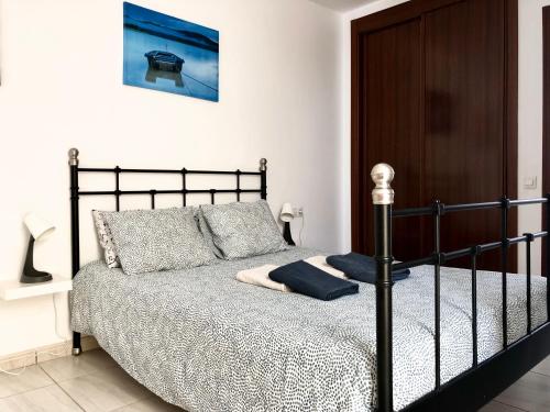 a bedroom with a black bed in a room at Casa Vega in Cotillo