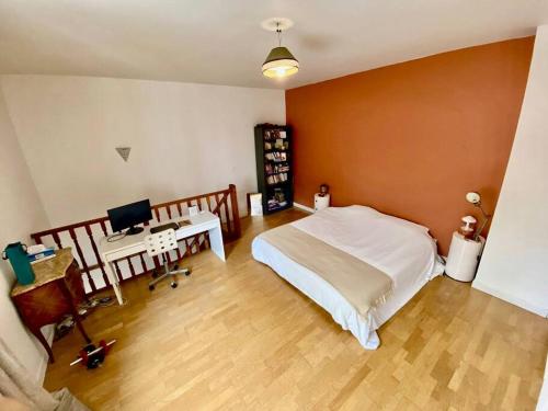 a bedroom with a bed and a desk with a computer at Superbe Maison à Saint-Ouen in Saint-Ouen