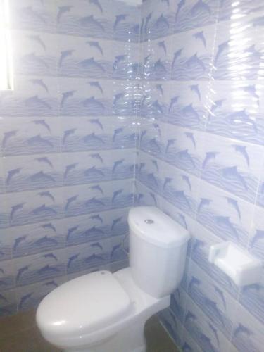a bathroom with a toilet with fish painted on the wall at Fidjrossé Beach in Cotonou