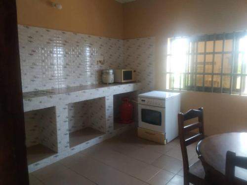 eine Küche mit einer Theke mit einem Herd und einer Mikrowelle in der Unterkunft Fidjrossé Beach in Cotonou