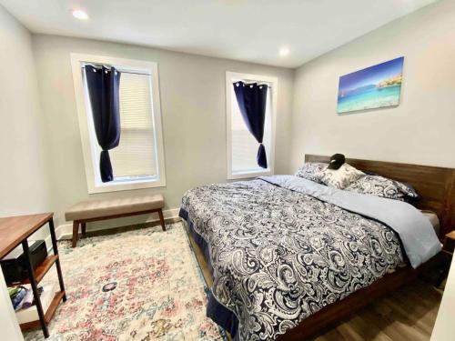 费城Philadelphia Deluxe Private Home的一间卧室设有一张床和两个窗户。