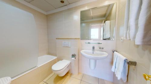 een witte badkamer met een wastafel en een toilet bij Vera Deep Purple by Oliva Nova in Oliva