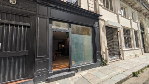 une devanture de magasin noire avec des vitres dans une rue dans l'établissement Les Frères Montgolfier - Le Marais - 80 m2, à Paris