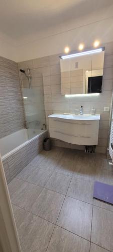 une salle de bain avec une baignoire, un lavabo et une douche dans l'établissement Beaulieu Azur - Elegant 3/4 room flat, City center and close to the beaches, à Beaulieu-sur-Mer