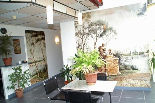 une chambre avec une table et des plantes sur le mur dans l'établissement Le Pré Fleuri, à Dax