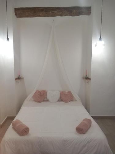 a white bed with two pillows on top of it at EL RINCON DEL ROMERAL in Pegalajar