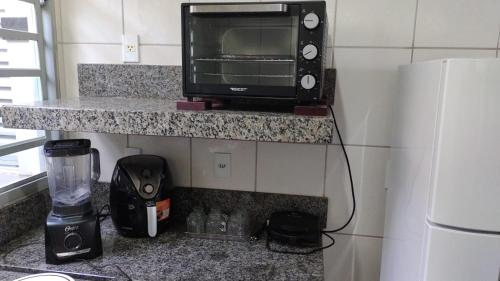 a microwave sitting on a counter in a kitchen at Casa Bela Vista da Serra da canastra in São Roque de Minas