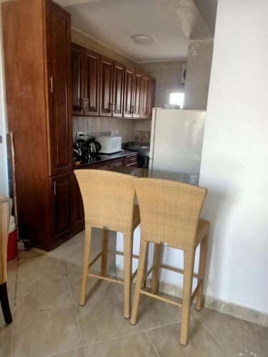 a kitchen with two chairs and a white refrigerator at فيلا مريم in Cairo