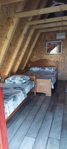 dwa łóżka na poddaszu domku z bali w obiekcie Etno selo Šapat w mieście Šavnik