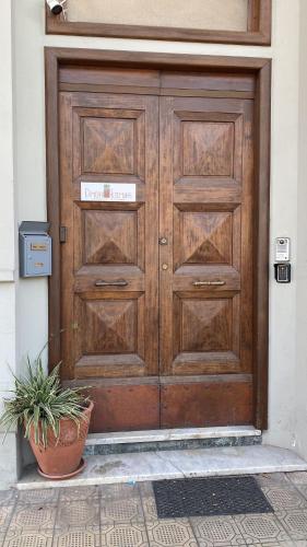 a wooden door with a potted plant in front of it at Dimora Altemura in Lucca