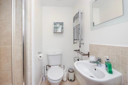 a white bathroom with a toilet and a sink at Vibrant Clapham Double bedroom in London