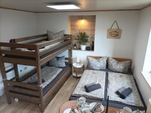 two bunk beds in a room with a table at Apartment Bräustübel, free Wi-Fi, Parken, Grillecke, nähe Rennsteig in Lehesten
