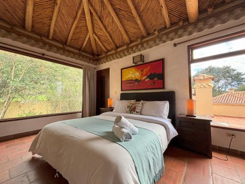 sypialnia z łóżkiem i dużym oknem w obiekcie ApartaHotel La Leyenda w mieście Villa de Leyva