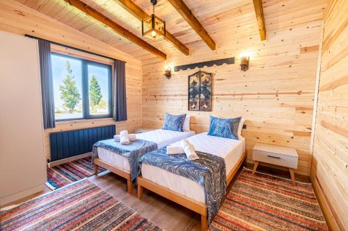 um quarto com 2 camas num chalé de madeira em Aronia Bungalow em Elmalık