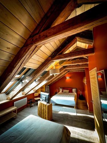 une chambre mansardée avec un grand lit dans une pièce dans l'établissement La Ferme du Bien-etre, à Saint-Julien-Chapteuil