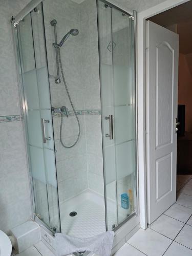 une douche avec une cabine en verre dans une salle de bain dans l'établissement Appartement calme bien équipé, à Lèves