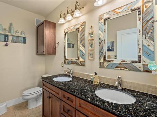 baño con 2 lavabos, aseo y 2 espejos en The Perfect Bay-Front Destination, en Galveston