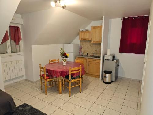 una piccola cucina con tavolo e sedie in una stanza di Appartement calme bien équipé a Lèves