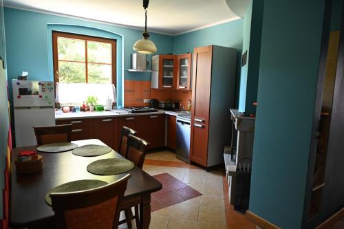 a kitchen with a table and a kitchen with blue walls at Strażnica Pod Lasem in Lasowka