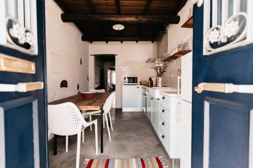 a kitchen with a table and chairs in a room at Casa do Sossego Monsaraz in Monsaraz