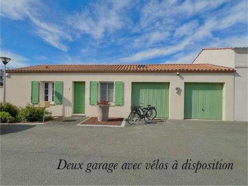 een huis met groene deuren en een fiets geparkeerd aan de voorkant bij La Maison du Bonheur in Rochefort