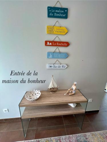 a table with a sign on a wall at La Maison du Bonheur in Rochefort