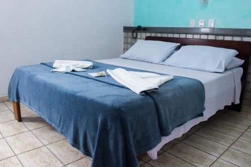a bed with two towels on top of it at Hotel São Charbel in Ubatuba