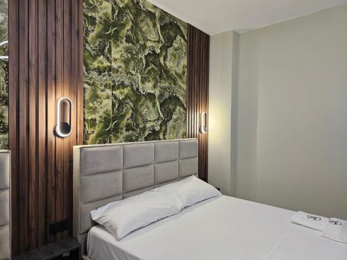 a bedroom with a bed and a painting on the wall at WG Hotel in Ksamil