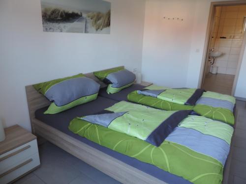 a bed with four pillows on it in a room at Pension am Kirchberg in Wehringen