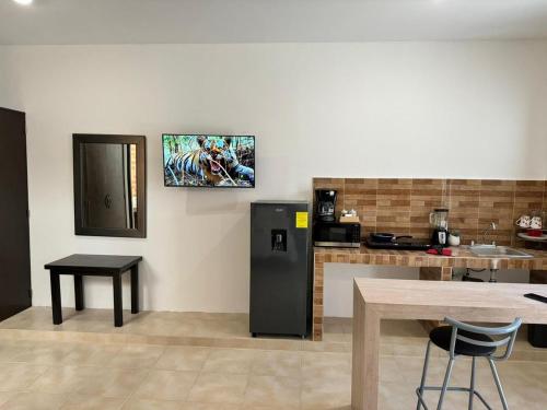 a kitchen with a black refrigerator and a table at ESTUDIOS CORONADO in Cabo San Lucas