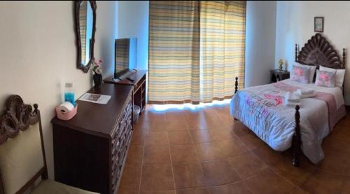 ein Schlafzimmer mit einem Bett und einem Schreibtisch in einem Zimmer in der Unterkunft Propriedade dos Seixos in Moledo