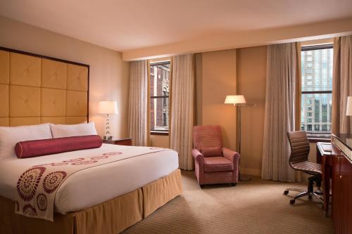 a hotel room with a bed and a desk and window at Millennium Knickerbocker Chicago in Chicago