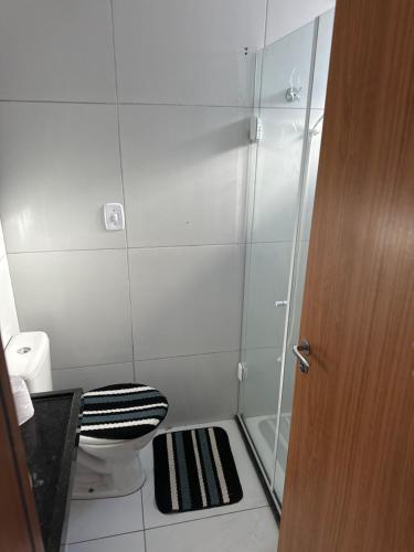 uma casa de banho com um WC e uma cabina de duche em vidro. em Ap gramame em João Pessoa