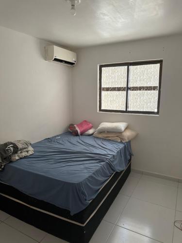 uma cama num quarto com uma janela em Ap gramame em João Pessoa