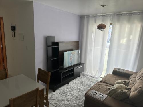uma sala de estar com um sofá e uma televisão em Ap gramame em João Pessoa
