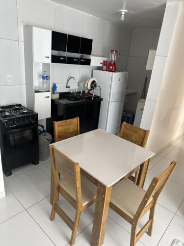uma cozinha com uma mesa, cadeiras e um fogão em Ap gramame em João Pessoa