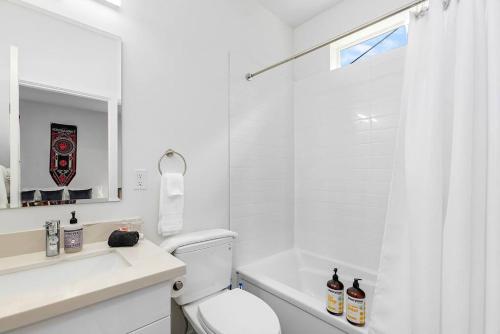 La salle de bains blanche est pourvue d'une douche et de toilettes. dans l'établissement Highgarden The Seat of House Tyrell Sweet Suite, à Seattle