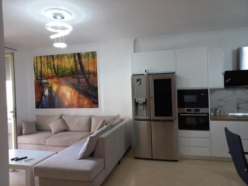 a living room with a couch and a kitchen at Lungomare Apartament Sea View in Vlorë