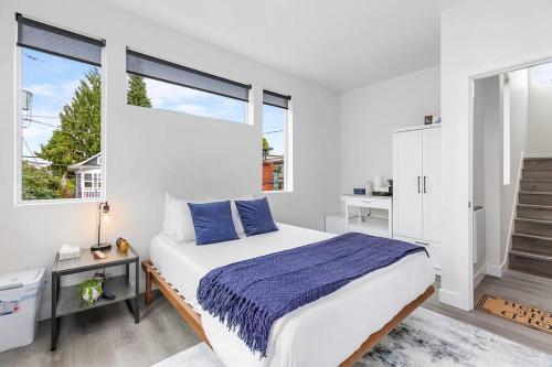 a white bedroom with a large bed and two windows at Highgarden The Seat of House Tyrell Sweet Suite in Seattle