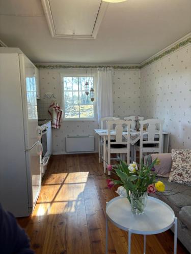 een woonkamer met een bank en een tafel met bloemen bij Gästhus i gårdsmiljö in Forsheda