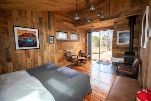 een slaapkamer met houten wanden, een bed en een televisie bij Gljásteinn by Golden Circle in Laugarvatn