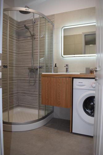 a bathroom with a shower and a washing machine at The Valley House in Kanakádes