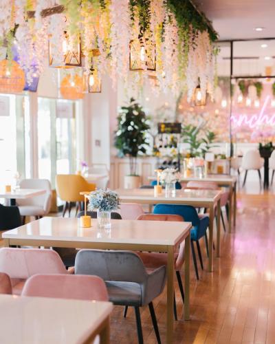 a dining room with tables and chairs and lights at Garden Suite Hotel and Resort in Los Angeles